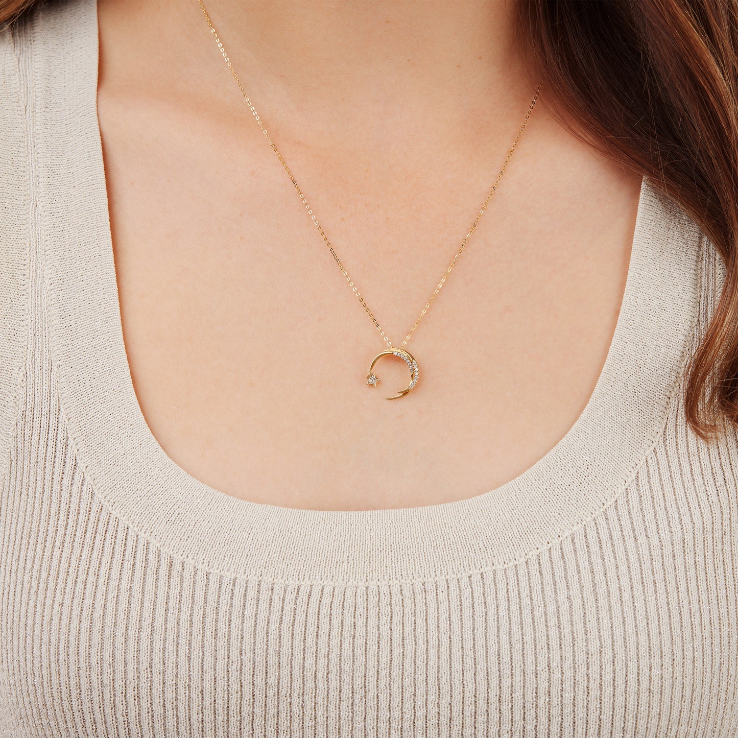 Gold necklace with a falling star diamond studded pendant worn by a woman.